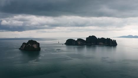 Drone-footage-of-Hong-islands-in-Thailand-with-limestone-rock-formation-sticking-out-of-the-water-and-the-ocean-in-background