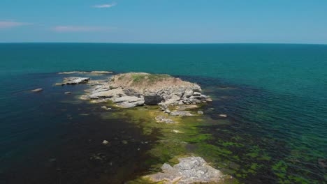 Aerial-drone-shot-of-big-cliffs-in-the-sea-with-vegetation-and-birds-1