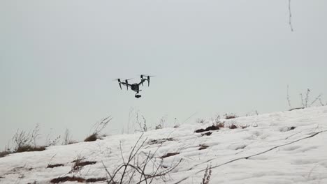 Big-Professional-Drone-DJI-Inspire-2-With-Video-Camera-Flies-Low-Over-The-Snow-While-Blowing-A-Strong-Wind
