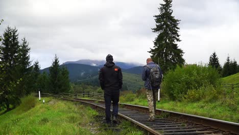 Two-men-go-on-the-railways-in-front-of-the-mountains