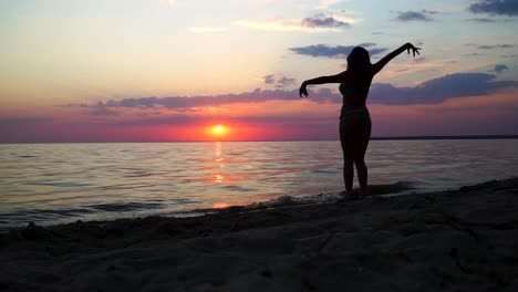 Tanzende-Silhouette-Eines-Mädchens-Im-Badeanzug-Vor-Dem-Meer-Bei-Sonnenuntergang