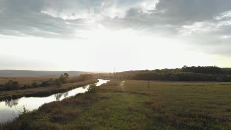 Luftaufnahme-Des-Flusses-Im-Grünen-Tal-Bei-Sonnenuntergang