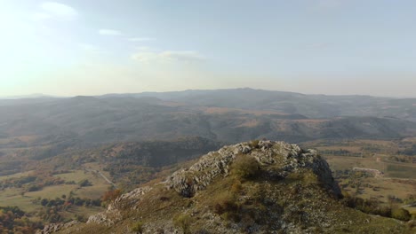 Aufspürung-Luftaufnahme-über-Felsigen-Hügel,-Grünes-Tal-Als-Hintergrund