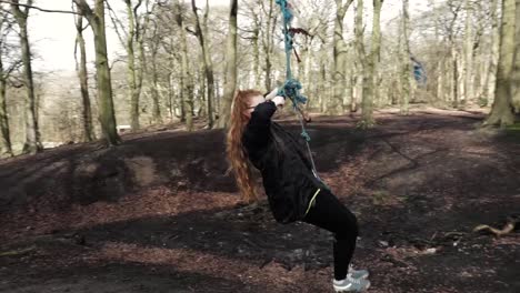 Pretty-young-woman-swinging-on-rope-swing-in-British-woodland-1