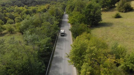 Aerial-shot,-drone-track-small-lorry-vehicle-uphill