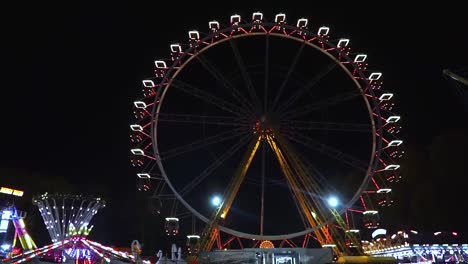 Rotating-ferris-wheel-at-amusement-park-with-neon-lights