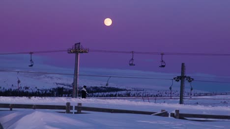 Person-riding-a-ski-lift-in-Idre-Fjäll-in-Sweden-during-a-colorful-sunset-1