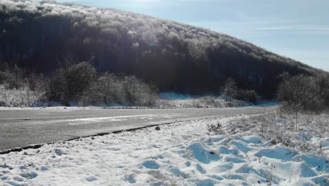 Breiter-Voller-Schuss-Eines-Autopasses-Und-Verschwindet-Auf-Trockener-Straße-An-Einem-Verschneiten-Wintertag