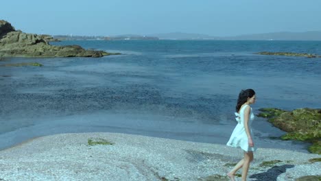 Slow-motion-shot-of-pretty-girl-in-white-dress-walk-on-the-beach-4