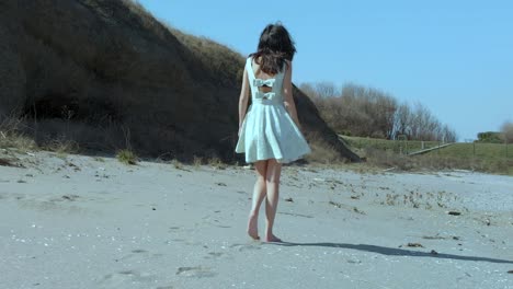 Zeitlupenaufnahme-Eines-Hübschen-Mädchens-Im-Weißen-Kleid,-Das-Am-Strand-Spazieren-Geht