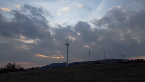 Motion-time-lapse-of-wind-generators-field-in-cloudy-day