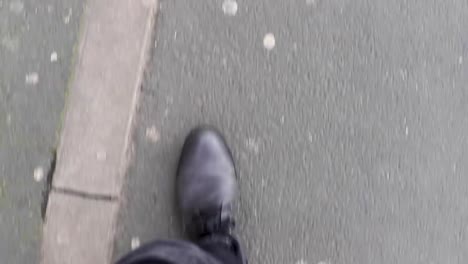 POV-man's-legs-walking-through-urban-city-streets,-stylish-boots-and-dark-jeans-1