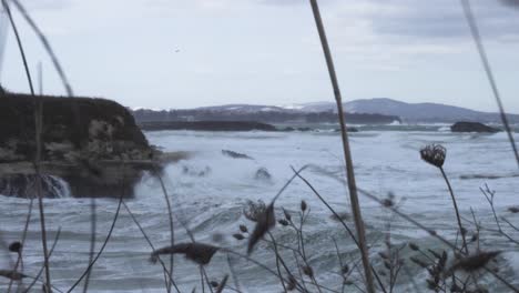 Panning-shot-of-winter-rocky-sea-coast-in-high-wind-and-big-waves-1