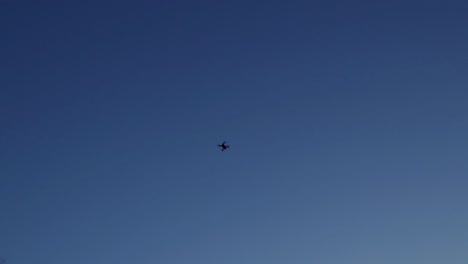 Drone-flying-isolated-as-a-silhouette-in-a-blue-sky