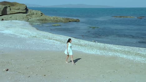 Pretty-girl-in-white-dress-walk-on-the-beach-1