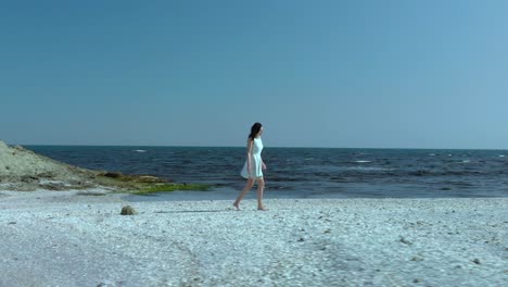 Pretty-girl-in-white-dress-walk-on-the-beach