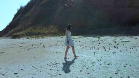 Slow-motion-shot-of-pretty-girl-in-white-dress-walk-on-the-beach-3