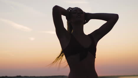 Silhouette-Eines-Mädchens,-Das-Bei-Einem-Wunderschönen-Sonnenuntergang-Am-Strand-Spazieren-Geht