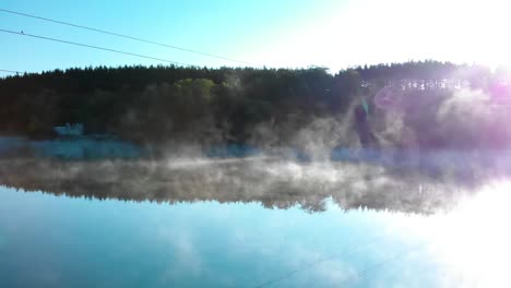 Foggy-lake-and-forest-after-sunrise---panning-shot-under-wires-1