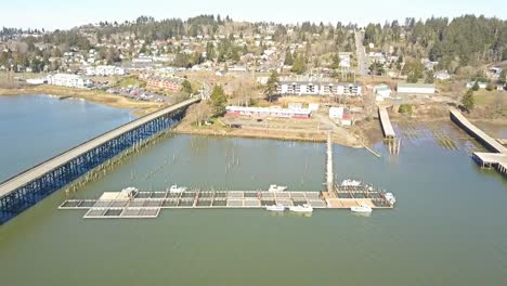 Aerial-Drone-view-over-boat-docks-bridge-and-small-town-on-a-hill