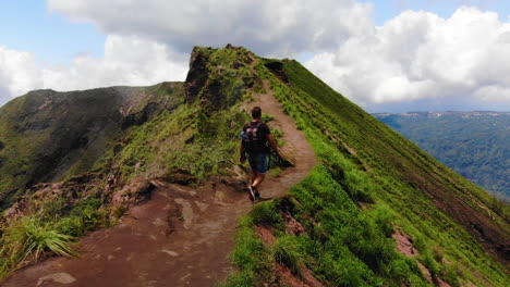 Asombroso-Paisaje-De-Un-Turista-Caminando-Cerca-Del-Cráter-De-Un-Volcán-Asiático-Activo-Mientras-Sale-Vapor-De-Un-Lado