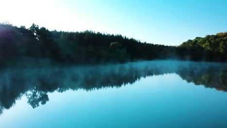 Foggy-lake-and-forest,-early-morning---panning-shot