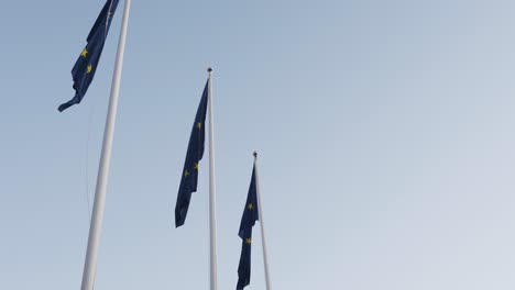 Mostrando-Tres-Banderas-De-La-Unión-Europea-Cerca-Del-Día-De-Las-Elecciones