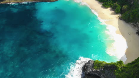 High-top-view,-shot-with-a-drone-of-a-tropical-island-with-clear-turquoise-waters,-amazing-beaches,-surrounded-by-mountains-and-forests