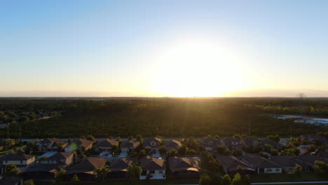 Schwenken-Sie-Während-Eines-Wunderschönen-Sonnenuntergangs-Mit-Einem-Linseneffekt-über-Häuser-Und-Eine-Orangenbaumfarm