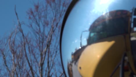 Mirror-on-school-bus-reflecting-into-trees-going-in-and-out-of-focus