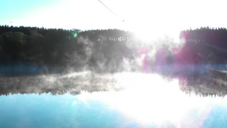 Foggy-lake-and-forest-after-sunrise---panning-shot-under-wires-2
