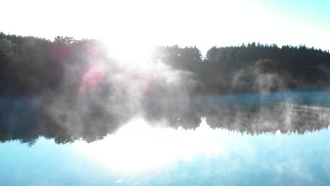 Sunrise-over-forest-in-front-of-foggy-lake---panning-shot-3
