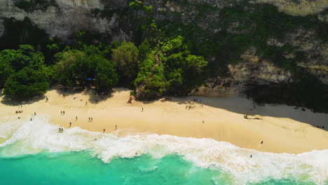 Top-down-view-of-a-crowd-of-tourists-at-a-tropical-sand-beach