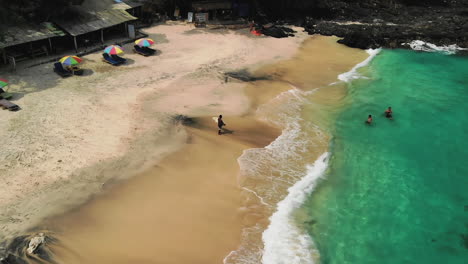 Menschen-Genießen-Die-Wellen-An-Einem-Weißen-Sandstrand-Im-Osten-Balis