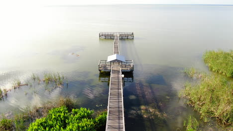 Flying-over-a-Florida-lakeside-dock-on-a-beautiful,-calm-Spring-Evening
