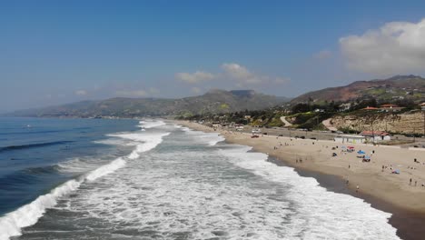 Drone-footage-of-Zuma-beach-with-waves-rolling-across-the-soft-white-sand