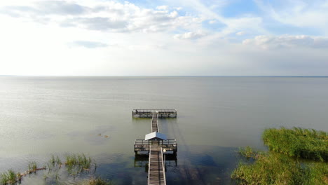 Flying-above-a-Florida-lakeside-dock-on-a-beautiful,-clam,-Spring-evening