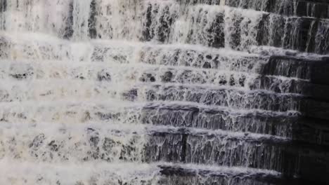 Wasser,-Das-Einen-Steinernen-Wasserfall-Hinunterläuft,-Umgeben-Von-Bäumen-Und-Viel-Grün-8