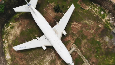 Descending-aerial-top-down-view-of-the-abandoned-airplane-in-Bali,-Indonesia