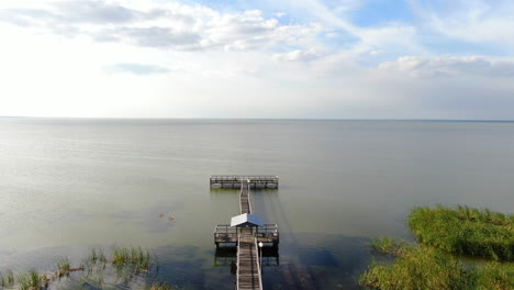 Flying-over-a-lakeside-dock,-landing-in-a-park-on-Lake-Apopka,-Florida