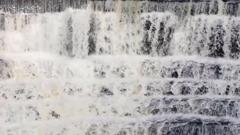 Wasser,-Das-Einen-Steinernen-Wasserfall-Hinunterläuft,-Umgeben-Von-Bäumen-Und-Viel-Grün-7