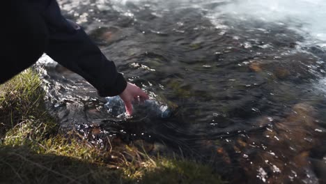 Nahaufnahme-Einer-Weiblichen-Hand,-Die-Eine-Plastikflasche-Mit-Frischem-Gletscherwasser-Aus-Dem-Wasserfall-Bruarfoss-In-Island-Füllt-1