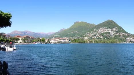 Panning-shot-of-the-beautiful-coastline-in-Lugano,-Switzerland-during-a-sunny-day
