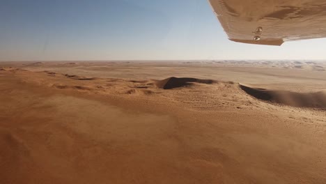 Looking-out-under-the-wing-across-the-endless-dunes-of-the-Namib-desert