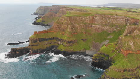 Luftüberblick-über-Steile-Klippen-Und-Ozeanische-Wellen,-Die-An-Der-Felsigen-Küste-Nordirlands-Plätschern