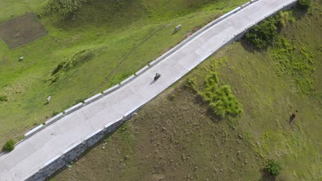 A-spotlight-drone-shot-of-a-man-riding-a-scooter-in-Batanes