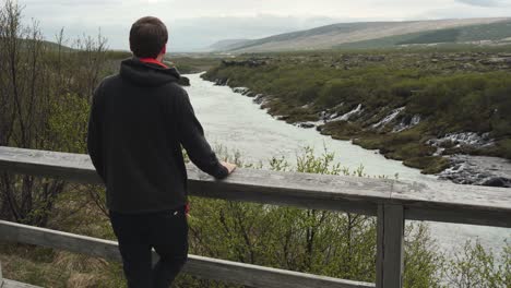 Handsome-young-male-looking-at-a-beautiful-view-at-Barnafoss-waterfall-in-Iceland