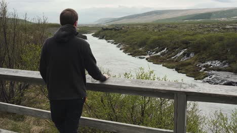 Handsome-young-male-looking-at-a-beautiful-view-at-Barnafoss-waterfall-in-Iceland-1