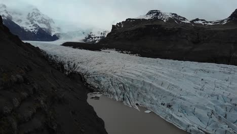 Luftaufnahmen-über-Dem-Svinafellsjökull,-Die-Die-Gletscher-Und-Die-Riesigen-Schneebedeckten-Berge-Im-Hintergrund-Zeigen-1