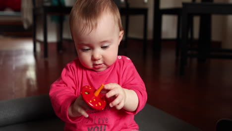 Cute-little-baby-plays-in-front-of-the-camera-with-a-wood-toy,-shot-in-slow-motion-1